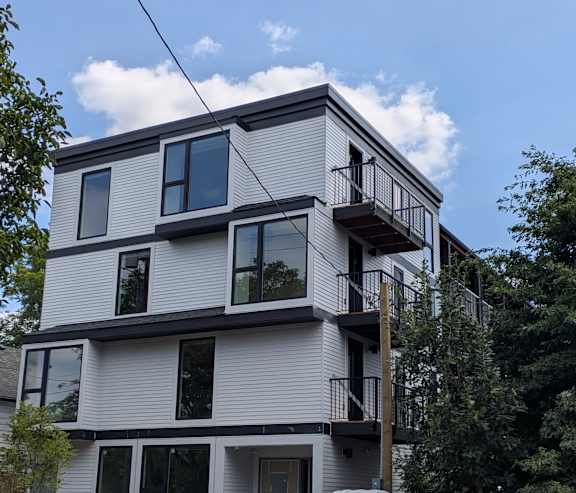 A modern multi-story building with balconies and large windows.