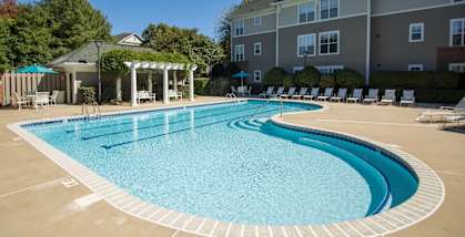 A large outdoor swimming pool with a pavilion and sun loungers.