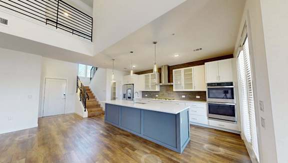 A spacious kitchen with wooden floors and modern appliances.