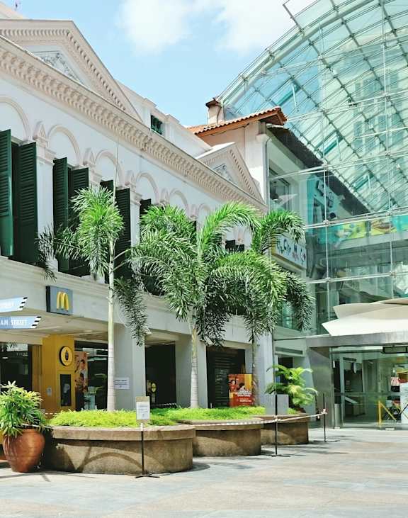 A white building with green shutters and a McDonald's sign in front.