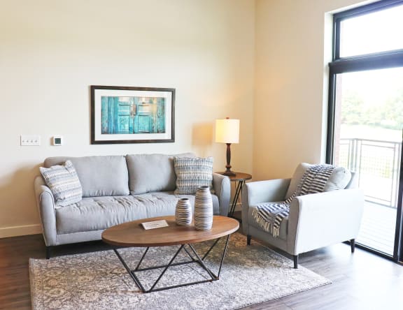 a living room with a couch and a chair and a table at Wildhorse Apartments, Chesterfield, 63017