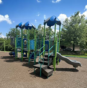 a swing set in a park next to a tree