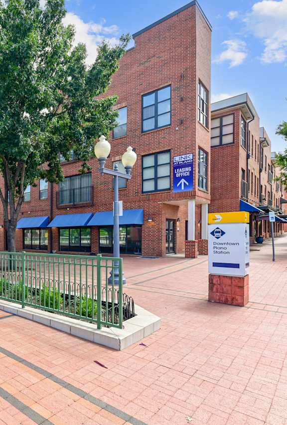 A train station with a red brick building and a blue awning.