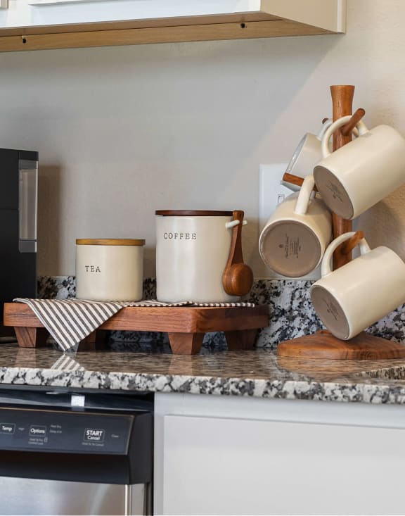 a kitchen with a coffee maker and a counter top with coffee cups and a microwave at Hillcrest Village, Springdale, AR