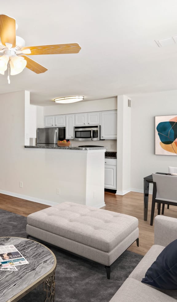 a living room with white walls and a ceiling fan at Stonebriar Woods Apartments, Overland Park, KS
