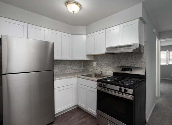 A kitchen with a stove, refrigerator, and cabinets.at Grant Meadows Apartments, Philadelphia Pennsylvania
