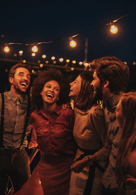 a group of people laughing on a boat at night