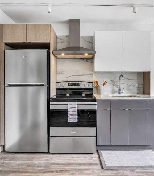 a small kitchen with stainless steel appliances and white cabinets at Up House, Farmington, Connecticut