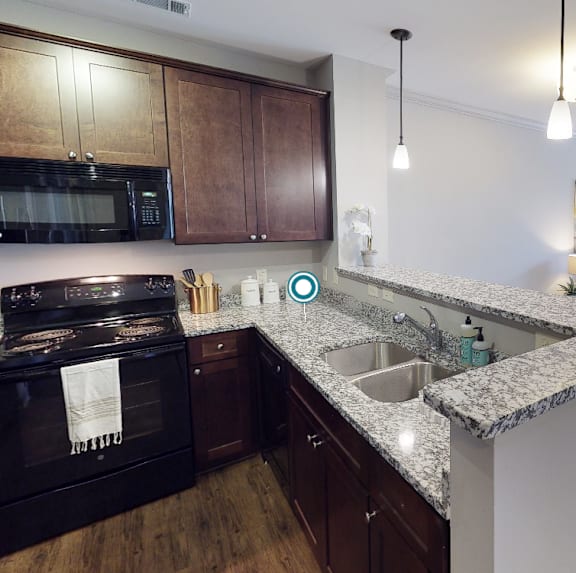 an open kitchen and living room with a granite counter top at Midtown Row, Alabama, 36106