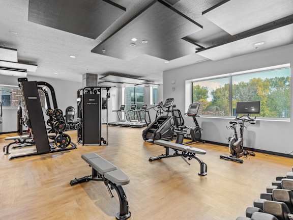 the gym has plenty of exercise equipment and a large window at Wilmington Flats Apartments, Utah, 84106