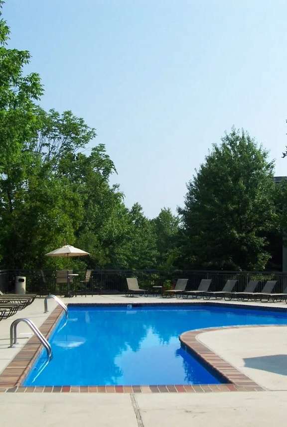 A large swimming pool surrounded by lounge chairs and umbrellas.