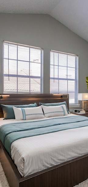 A bedroom with a large bed and a painting on the wall.