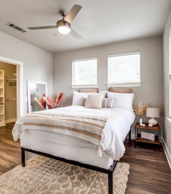 A bedroom with a bed, a ceiling fan, and a rug.