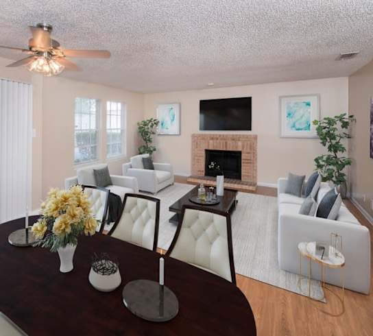 A living room with a fireplace, a TV, and a ceiling fan. at Tradewinds, Windcrest, 78239