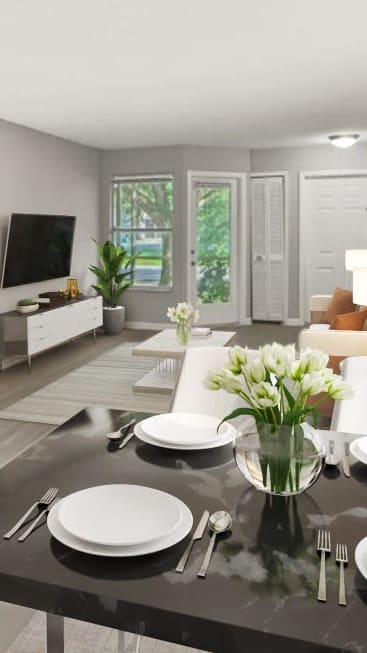 Dining room table with plates and a vase of flowers on top of it at Aqua Bay Apartments in Naples, FL 34116