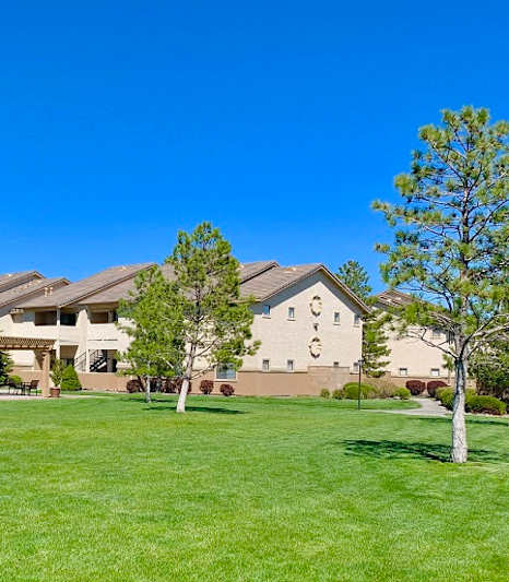 A large building with a playground in front of it at Sharlands Terrace Apartments, Apartments, Reno, NV