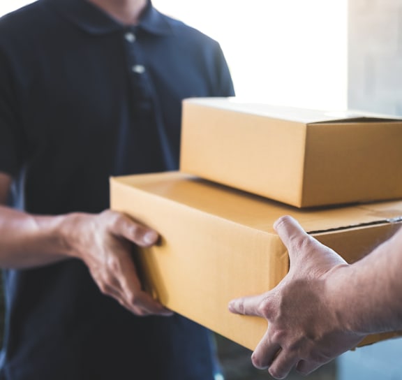 A man in a blue shirt is handing over a package to another person.