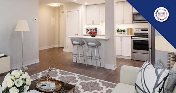 A modern living room with a bar area in the kitchen.