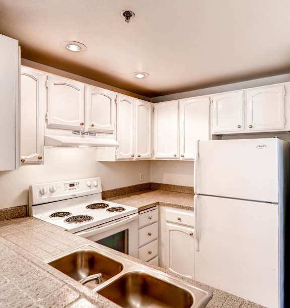 A kitchen with white cabinets and appliances.