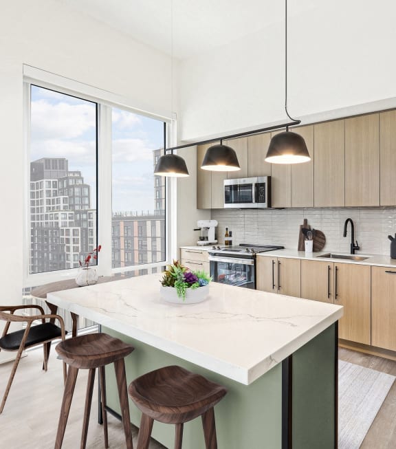 a kitchen with a large island and a stainless steel refrigerator