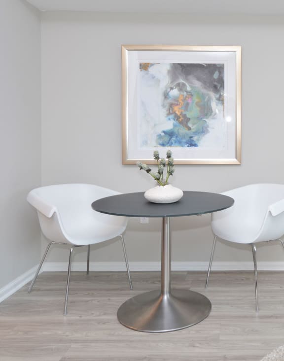 a dining room with a table and chairs and a painting on the wall at Apartments at Denver Place, Denver, CO 80202