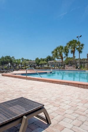 a swimming pool with benches and tables next to it