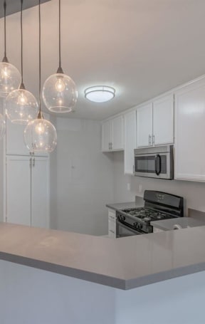 a kitchen with white cabinets and a counter top at Warner Center Townhomes, Canoga Park, CA 91303