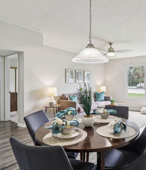 A dining room with a table set for four.