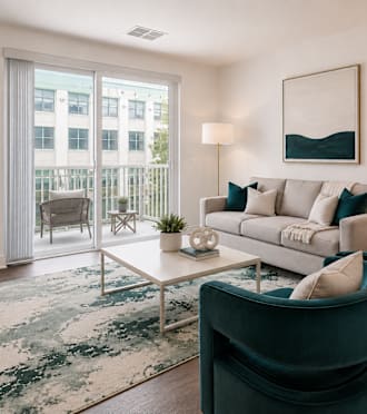 A living room with a grey sofa and a wooden table.