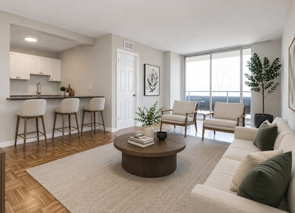 A living room with a white couch, a coffee table, and a kitchen area in the background.