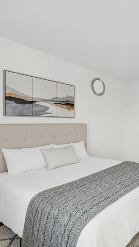 A bedroom with a large bed and a wooden nightstand at Fullerton Court Apartments, Illinois 60614