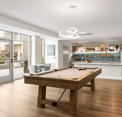 A room with a pool table and a bar.