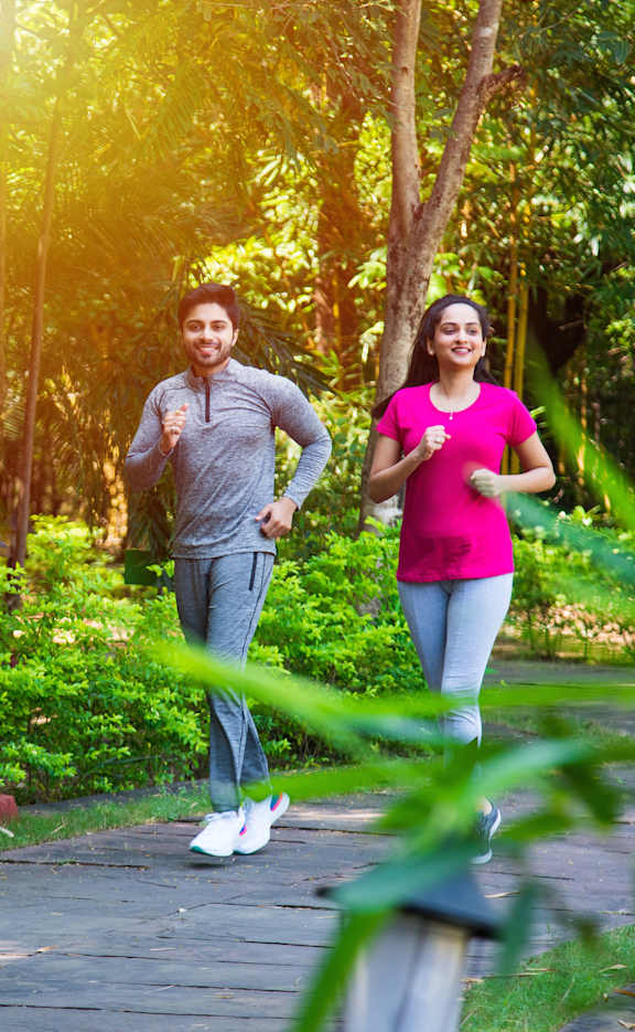 a man and a woman walking down a path in a park