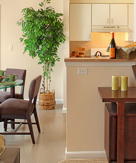 a living room and dining room with a desk with a laptop at Renaissance Place at Grand Apartments