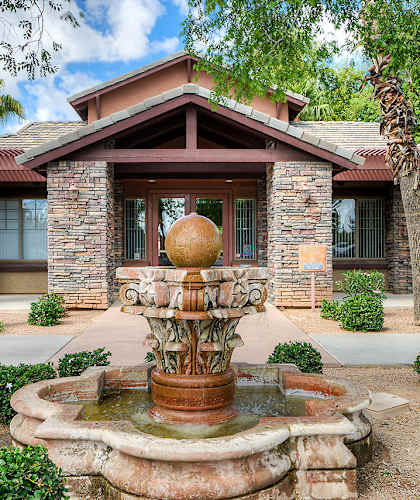 A house with a fountain in front of it.