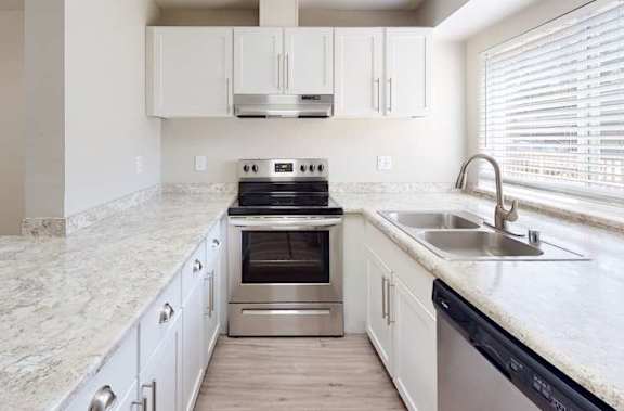 A kitchen with a marble countertop and stainless steel appliances at The Village at Seeley Lake Apartments, Lakewood, 98499
