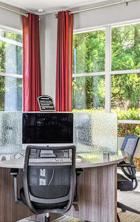 A room with a desk and chairs with a computer on it.