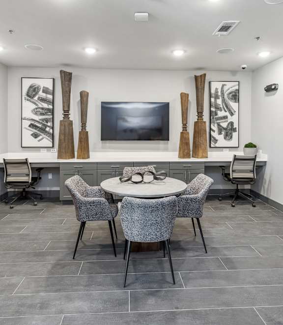 A modern room with a grey floor and a white table with chairs.