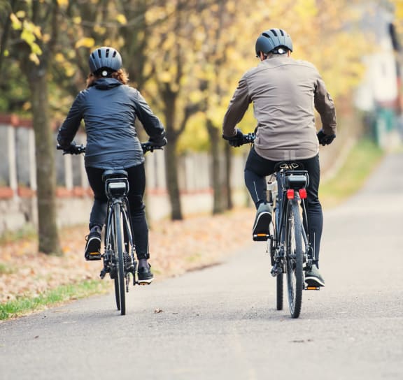 two people riding bikes down a path at Newport Village Apartments, Portage, Michigan