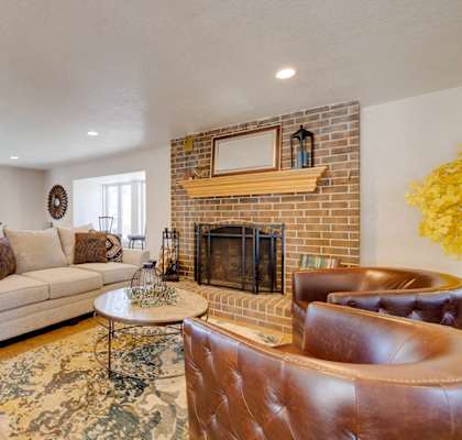 Living room with couch, coffee table, and fireplace in an apartment home setting at Olde English Village.