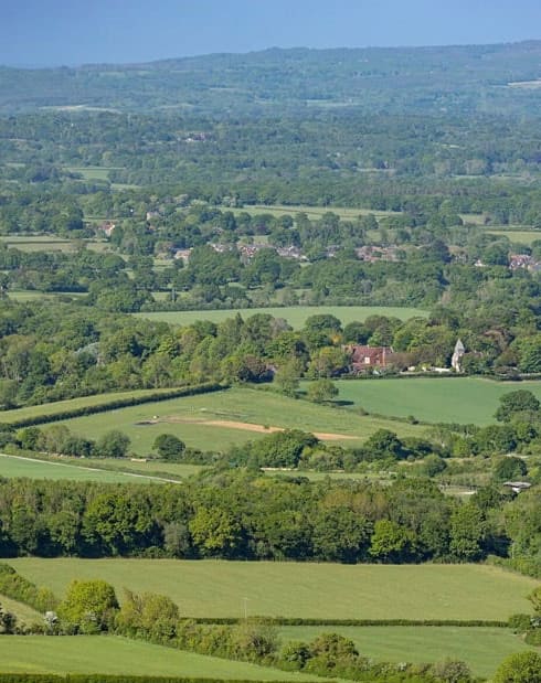 a view of the countryside with green fields and trees