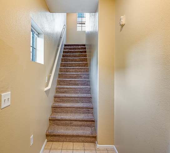 A hallway with a staircase leading to the second floor.