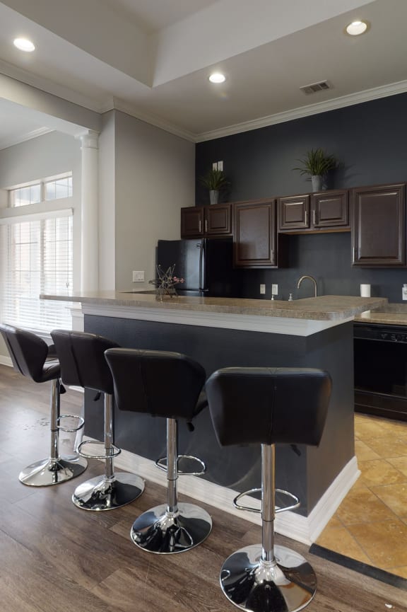 a kitchen with wooden cabinets and a black microwave