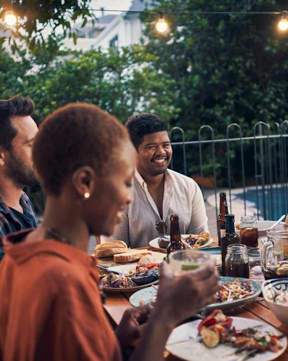 A group of people enjoying a meal together at an outdoor table.