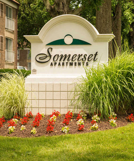 A Somerset Apartment building with a welcome sign and lease sign.