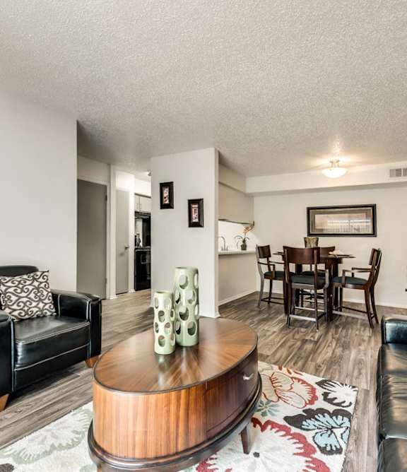 A living room with a black leather couch and a wooden coffee table.