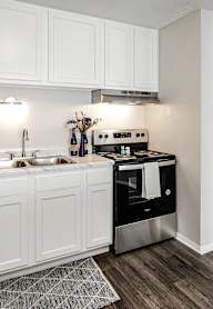 A modern kitchen with white cabinets and stainless steel appliances.