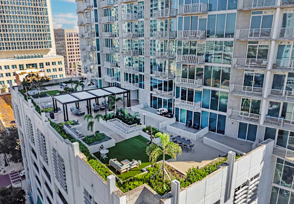 A modern building with a green roof and a glass balcony.