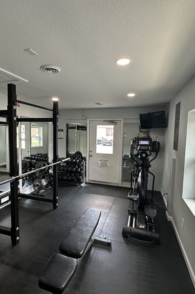 a home gym with a treadmill and weights