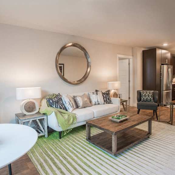 an open concept living room and dining area with a white dining table and rattan chairs
